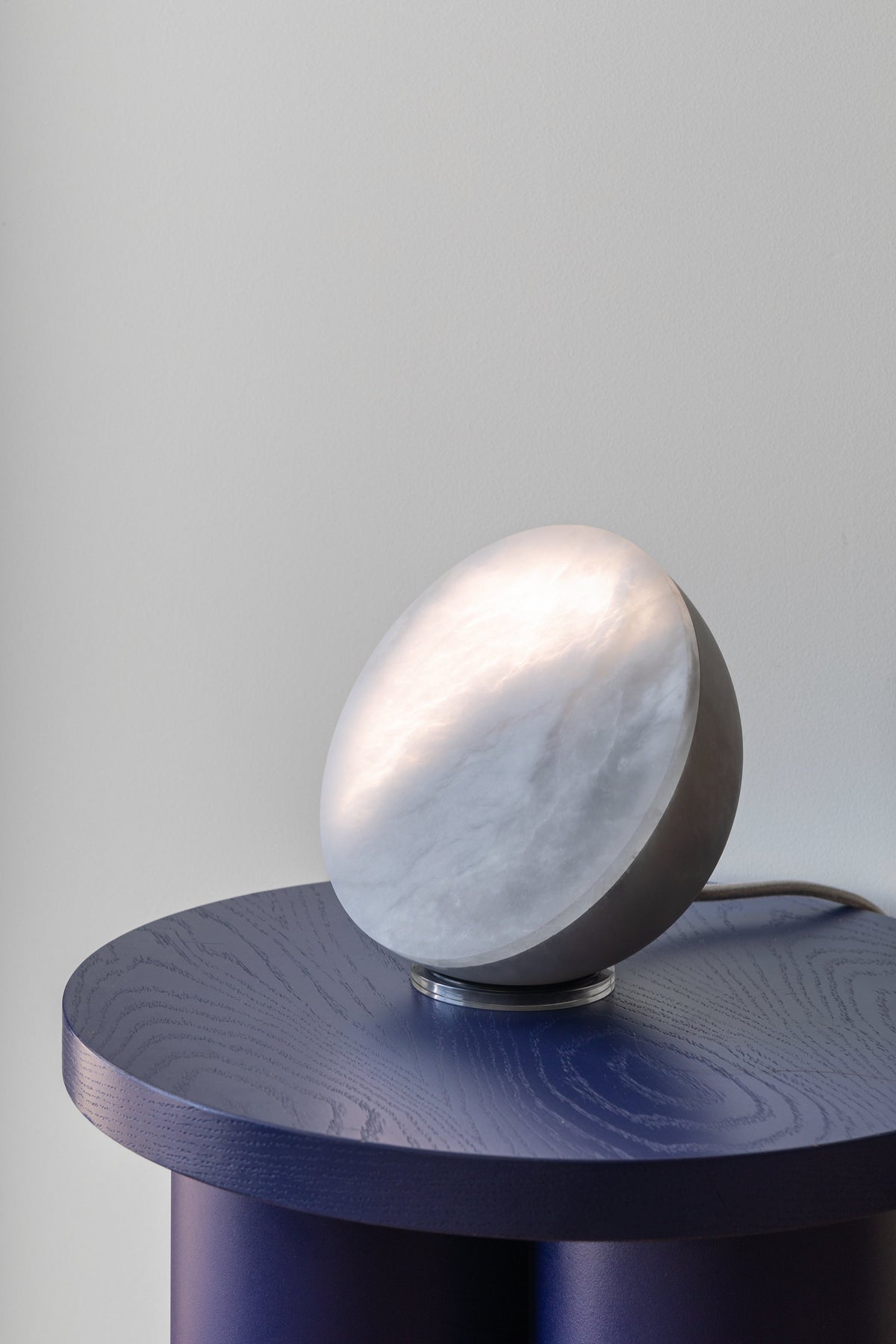 MOON Sixteen, leuchtend auf einem blauen Beistelltisch