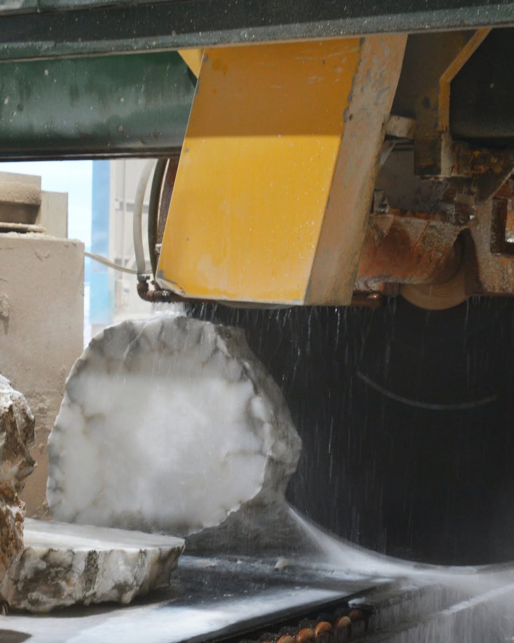 A saw cutting a block of alabaster