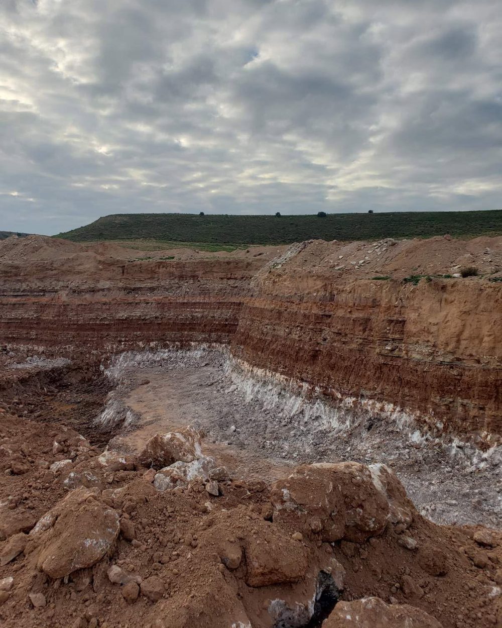 A quarry face in Aragón, layers of earth above a band of alabaster