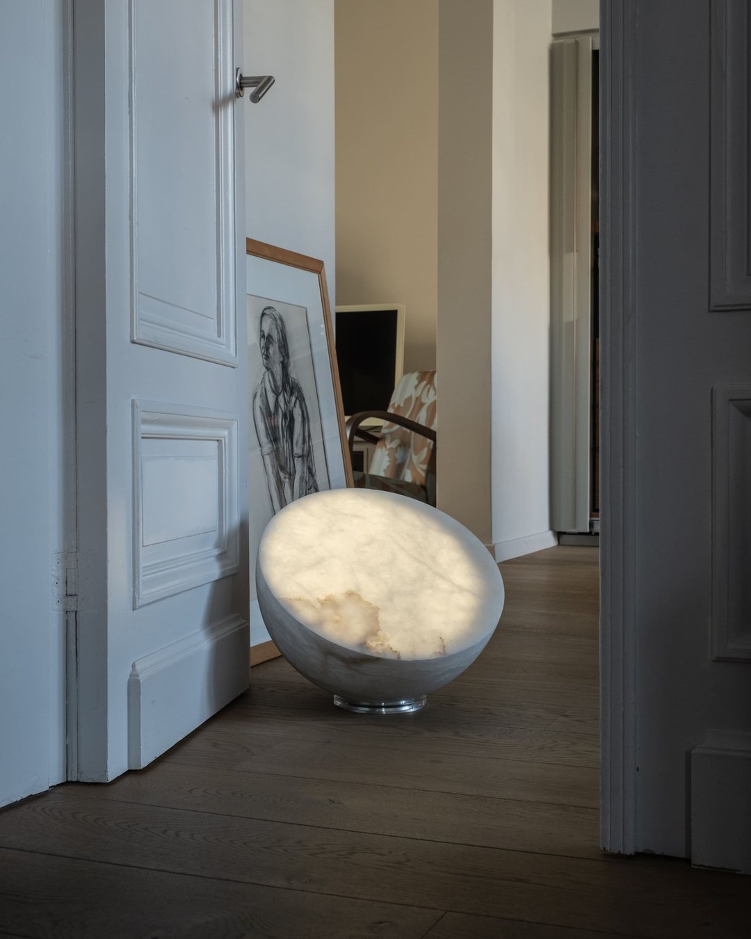 MOON Forty leuchtet am Boden neben einer offenen Tür.