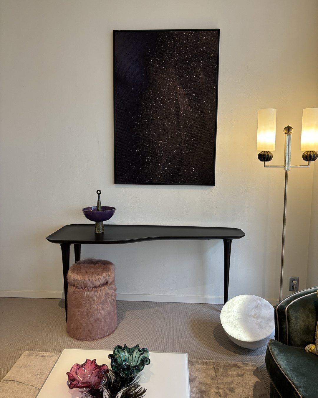 MOON Forty on the floor beneath a black console and a painting